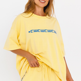 Yellow oversized lounge tee with blue CW logo – close up front view