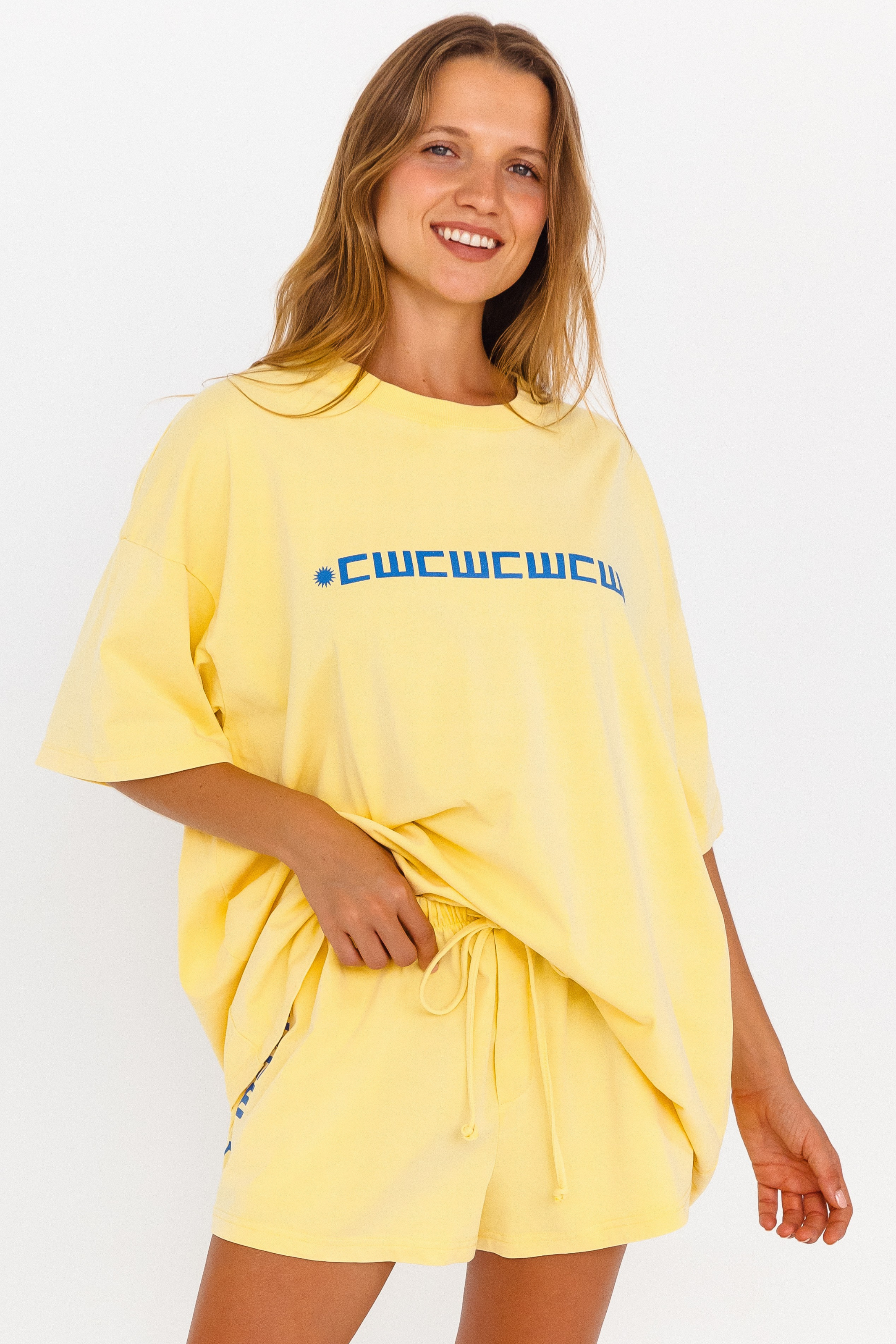 Yellow oversized lounge tee with blue CW logo – close up front view