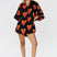 Black oversized shirt-style playsuit with red orange heart print – front view